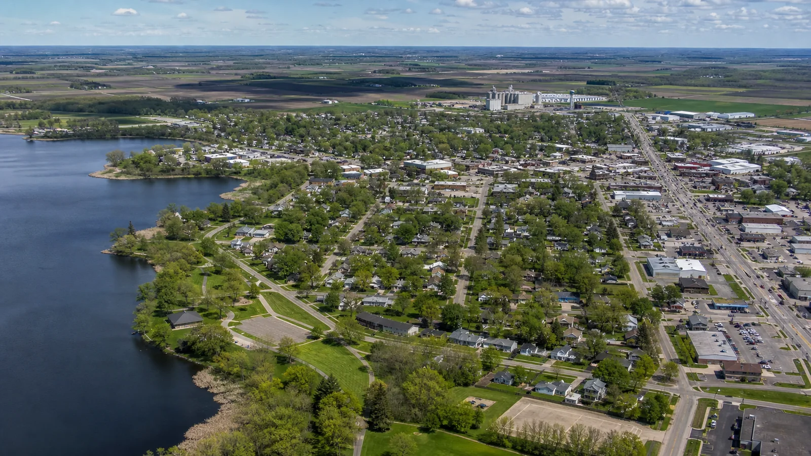 Editorial wide view of Buffalo Lake shoreline, public spaces, compact downtown, neighborhoods, healthcare and civic institutions, and employment areas in Buffalo