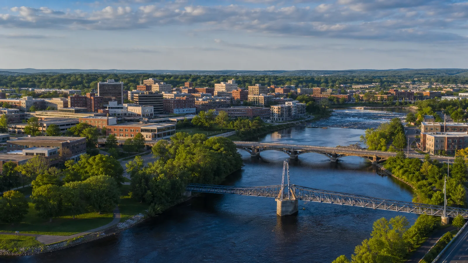 Editorial wide view of Chippewa and Eau Claire riverfront, pedestrian bridges, and downtown in Eau Claire